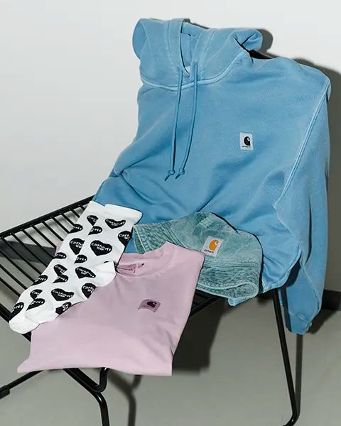 Close-up of a textile with a repetitive Carhartt WIP logo pattern, highlighting a stylish collaboration in workwear fashion.